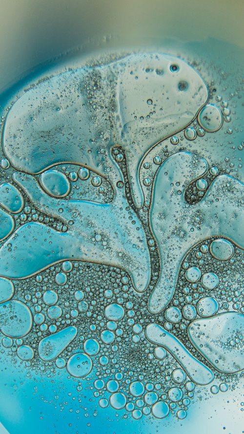 Free Intricate macro shot of blue oil and water bubbles creating an abstract pattern. Stock Photo