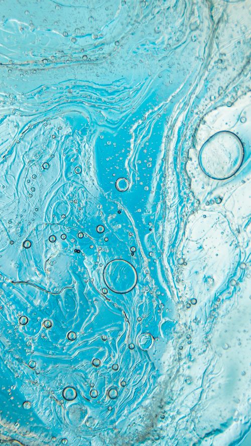 Free Detailed image of swirling blue liquid with air bubbles, creating an abstract and calming texture. Stock Photo