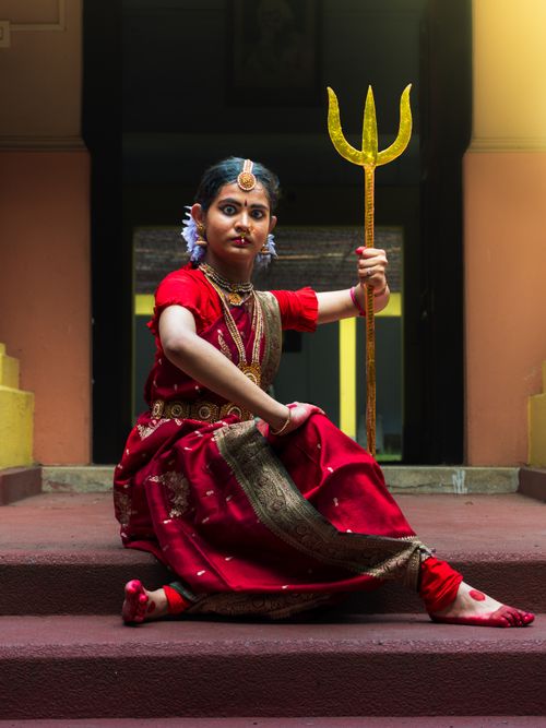 Free A woman in traditional Indian dress poses with a trident, showcasing cultural heritage. Stock Photo