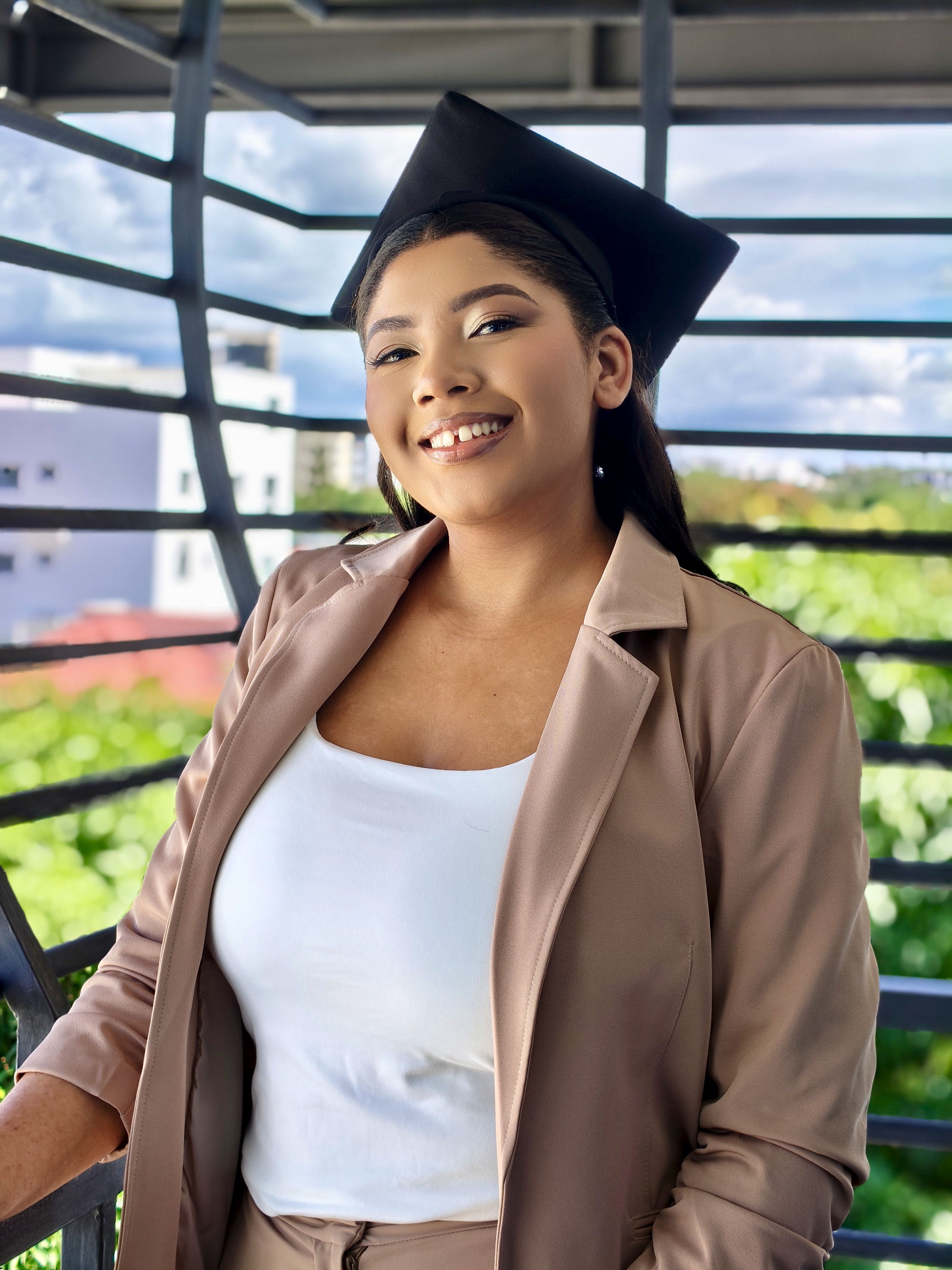 Young Woman in Graduation Attire Smiling Outdoors · Free Stock Photo