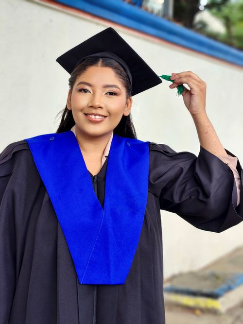Free Young woman proudly celebrates her graduation in cap and gown. Stock Photo