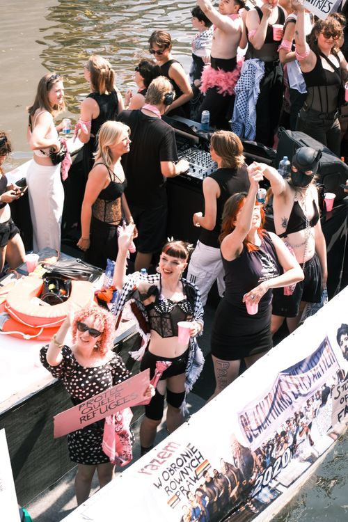 Free People joyfully celebrating on a boat in Amsterdam during a vibrant Pride event. Stock Photo