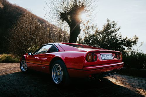 Free Vintage red Ferrari 328 GTS parked outdoors in picturesque Olgiasca, Italy. Stock Photo