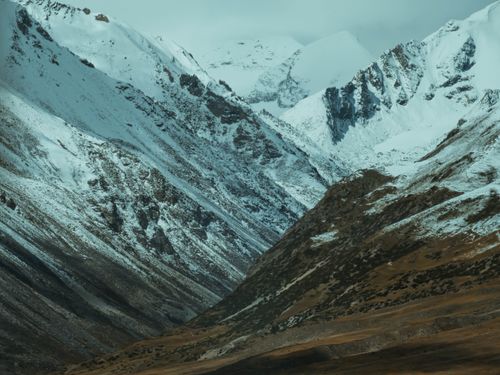Free A breathtaking view of a snow-covered mountain range showcasing rugged, majestic peaks under a wintry sky. Stock Photo