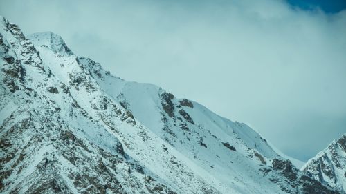 Free Majestic snow-covered mountain peaks under a cloudy sky, showcasing winter's beauty. Stock Photo