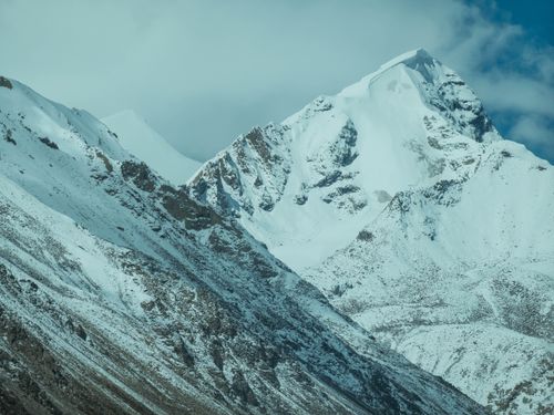 Free Majestic snow-covered peak under a blue sky, showcasing the beauty of serene mountainous landscapes. Stock Photo