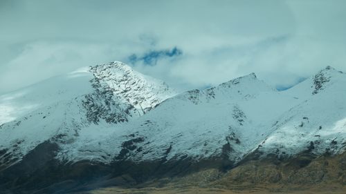 Free Scenic view of snow-capped mountains with clouds above, creating a dramatic landscape. Stock Photo