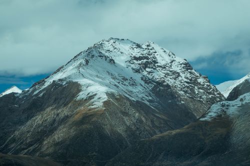 Free Breathtaking view of a snow-capped mountain peak under a cloudy sky. Stock Photo