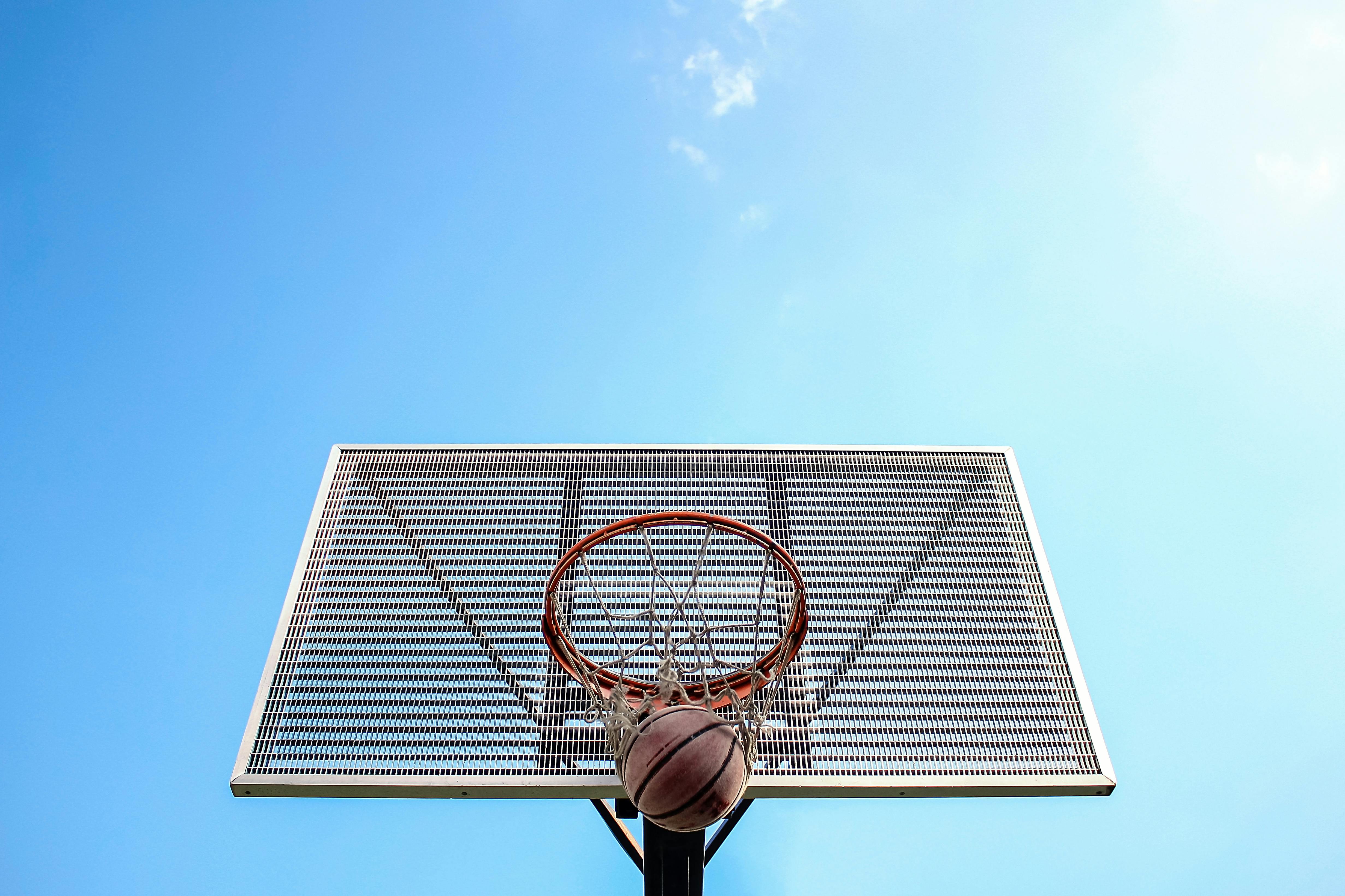 low angle shot of a ball going inside a hoop
