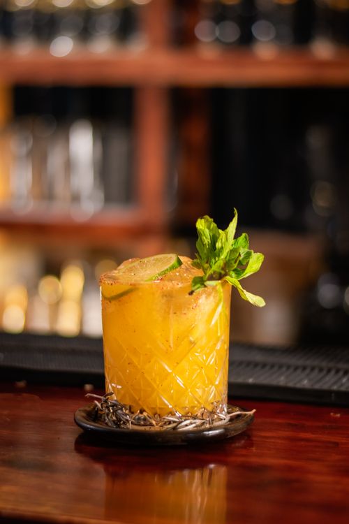 Free A vibrant citrus cocktail garnished with lime and mint in a Mexican bar setting. Stock Photo