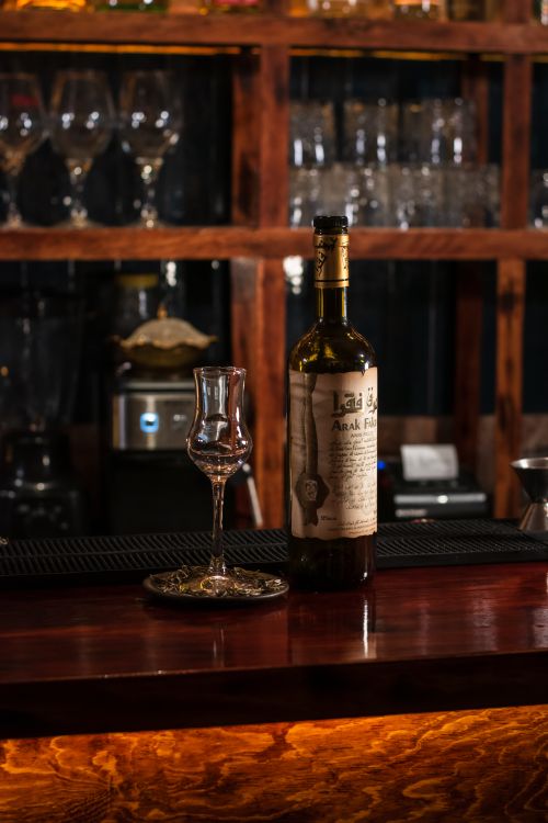 Free An artistic capture of a bar setting with a bottle and stemware, perfect ambiance. Stock Photo
