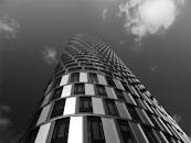 一座现代摩天大楼以黑白色调从引人注的角度与云层相映