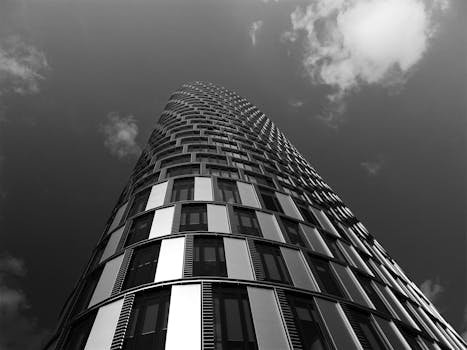 一座现代摩天大楼以黑白色调从引人注的角度与云层相映