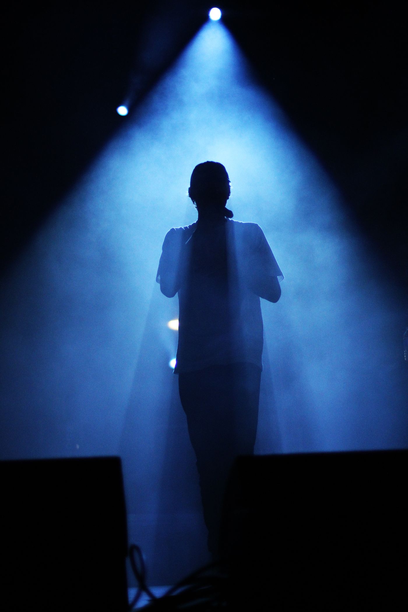 Performer silhouetted in blue stage light — photo by Thibault Dandré on Pexels