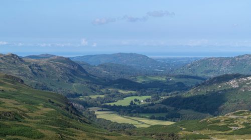 Free Stunning view of verdant valleys nestled between hills under a blue sky. Stock Photo