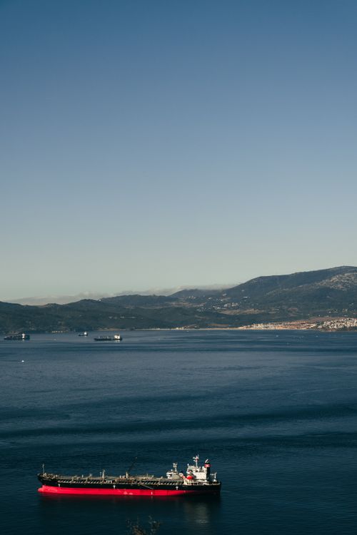Free Cargo ship in Gibraltar Bay under clear skies with distant mountains Stock Photo