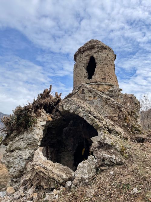 Free Weathered ancient stone ruins beneath a partly cloudy sky, showcasing historic architecture. Stock Photo