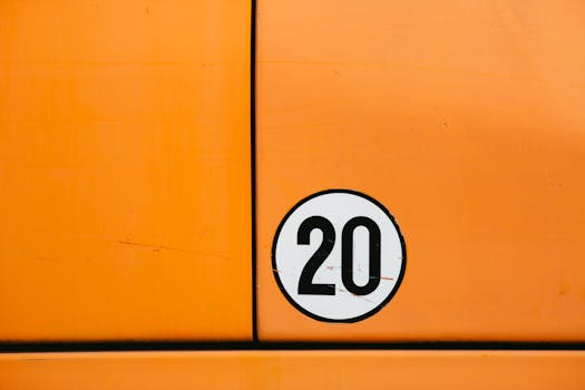 Close-up of a vintage orange vehicle door featuring a bold number 20 in a circle.