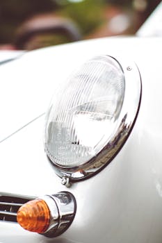 Detailed shot of a vintage car headlight showcasing its classic chrome design.