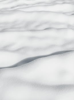 Smooth snow-covered landscape with soft shadows and white texture.