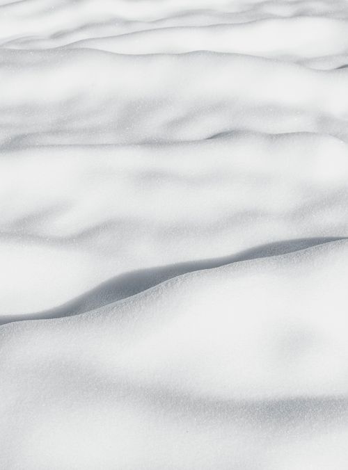 Free Smooth snow-covered landscape with soft shadows and white texture. Stock Photo