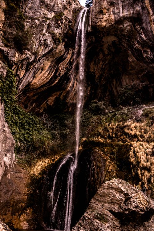 Free Magnificent waterfall cascading down rugged cliffs, contrasting nature's raw beauty. Stock Photo