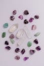 Set of colorful semiprecious stones placed chaotically on gray tabletop in jewelry store