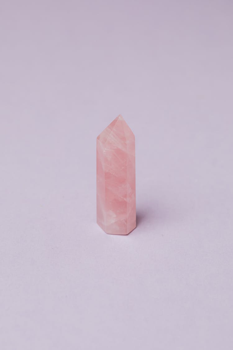 Light Pink Crystal Of Rose Quart Against Gray Background In Studio