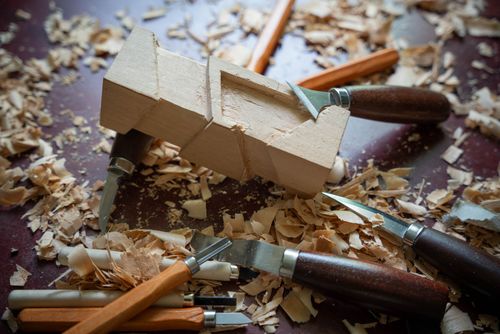 Free Close-up of woodworking tools and wood carving in progress, showcasing craftsmanship. Stock Photo