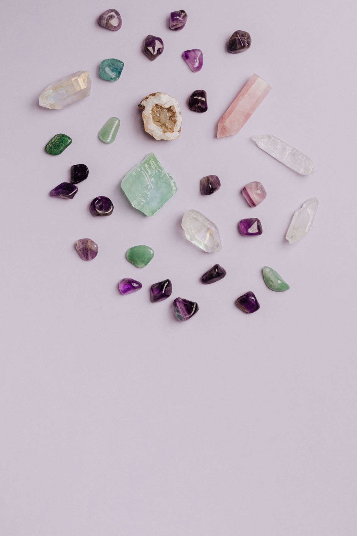 Collection of colourful gemstones and crystals arranged on a light background