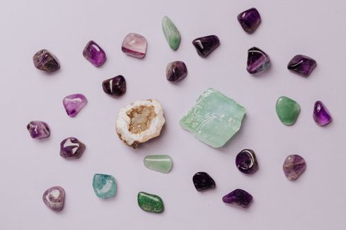 Free Flat lay of assorted polished gemstones including amethyst and jade on a light background. Stock Photo