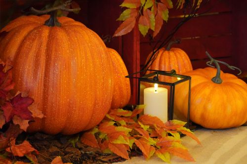 Free Warm autumn scene featuring pumpkins, leaves, and a candle. Stock Photo