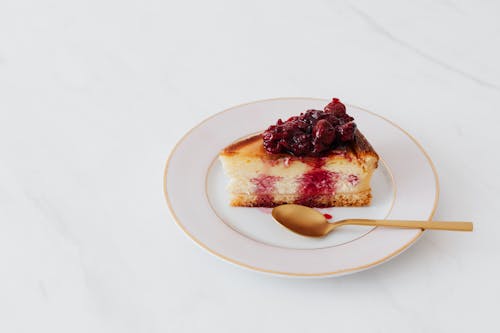 Piece of cheesecake on plate served with spoon