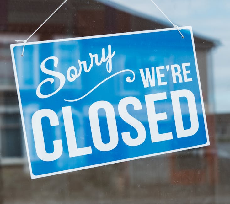 Photo by Ellie Burgin A blue and white 'Sorry We're Closed' sign hanging on a glass door.