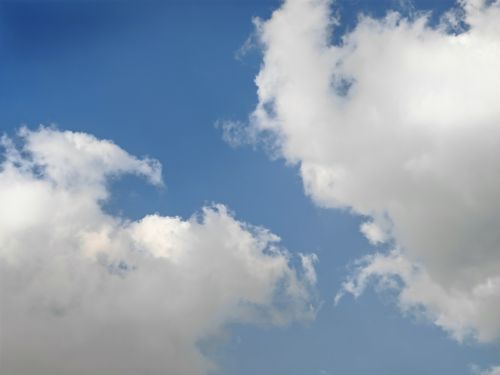 Free Blue sky featuring fluffy white clouds, perfect for serene and bright atmospheres. Stock Photo