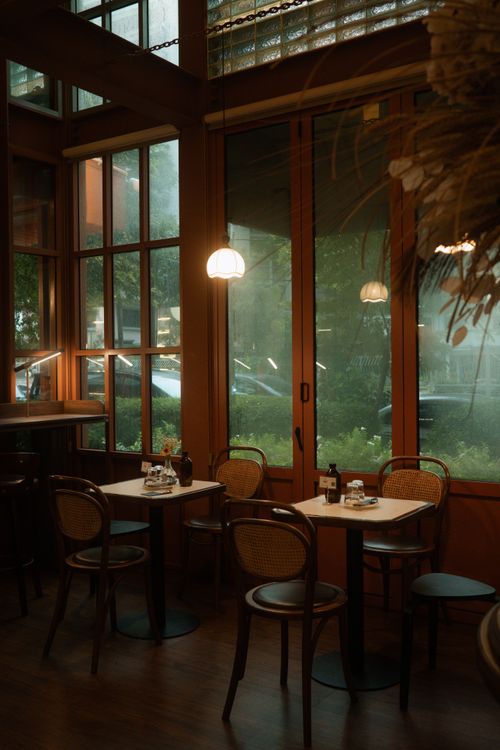 Free Warm, inviting cafe interior featuring wooden decor and soft lighting, ideal for relaxation. Stock Photo