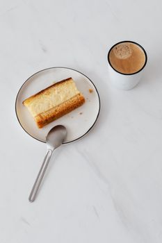 白色大理石桌子上，靠近一杯热咖啡的盘子里，甜馅饼的顶视图