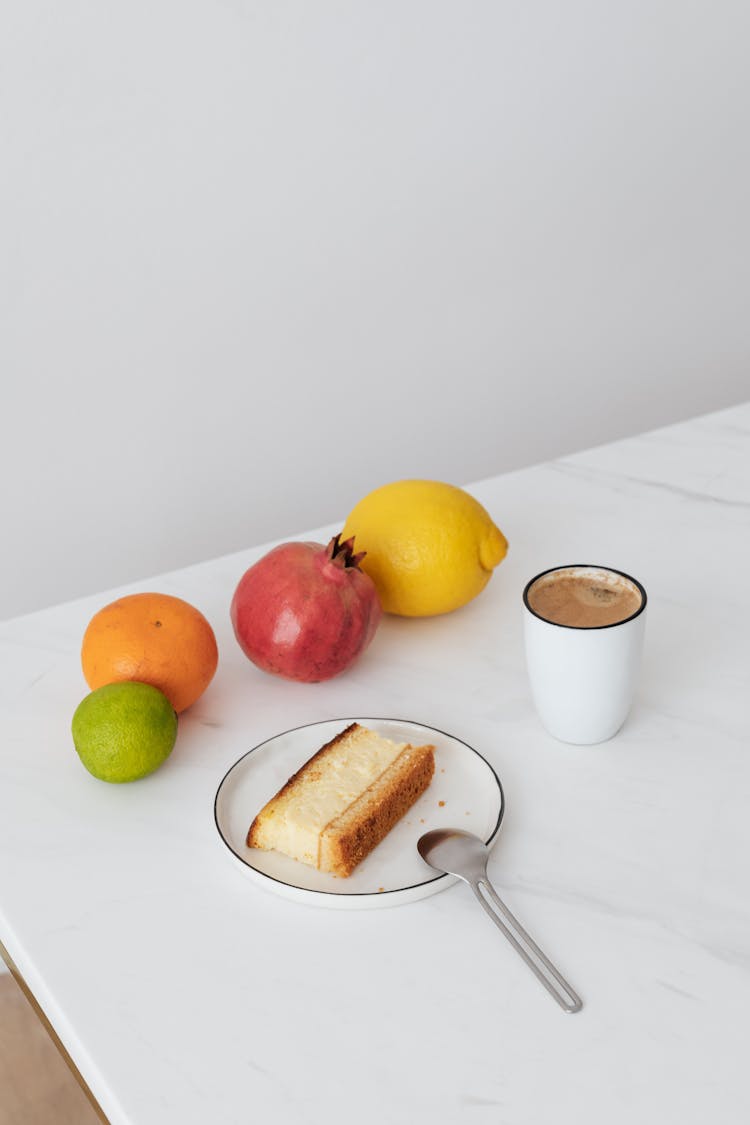 Piece Of Cake And Cup Of Cacao Near Fruit