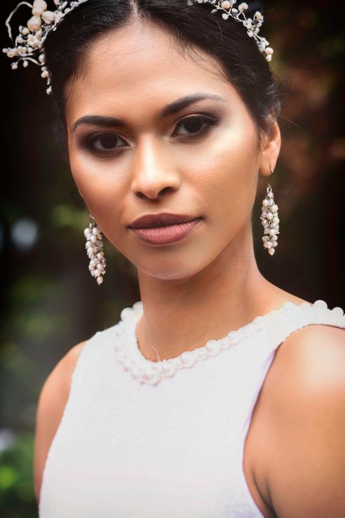 Free Close-up portrait of a beautiful bride with floral headpiece and earrings, perfect for wedding themes. Stock Photo