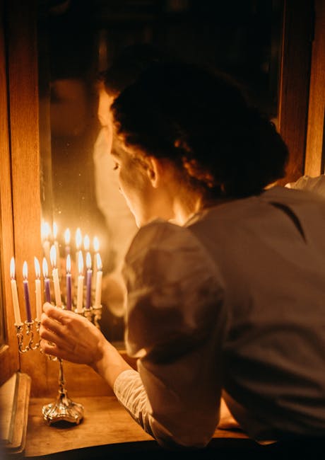 A woman lighting a menorah for Hanukkah in a cozy home setting, reflecting tradition.