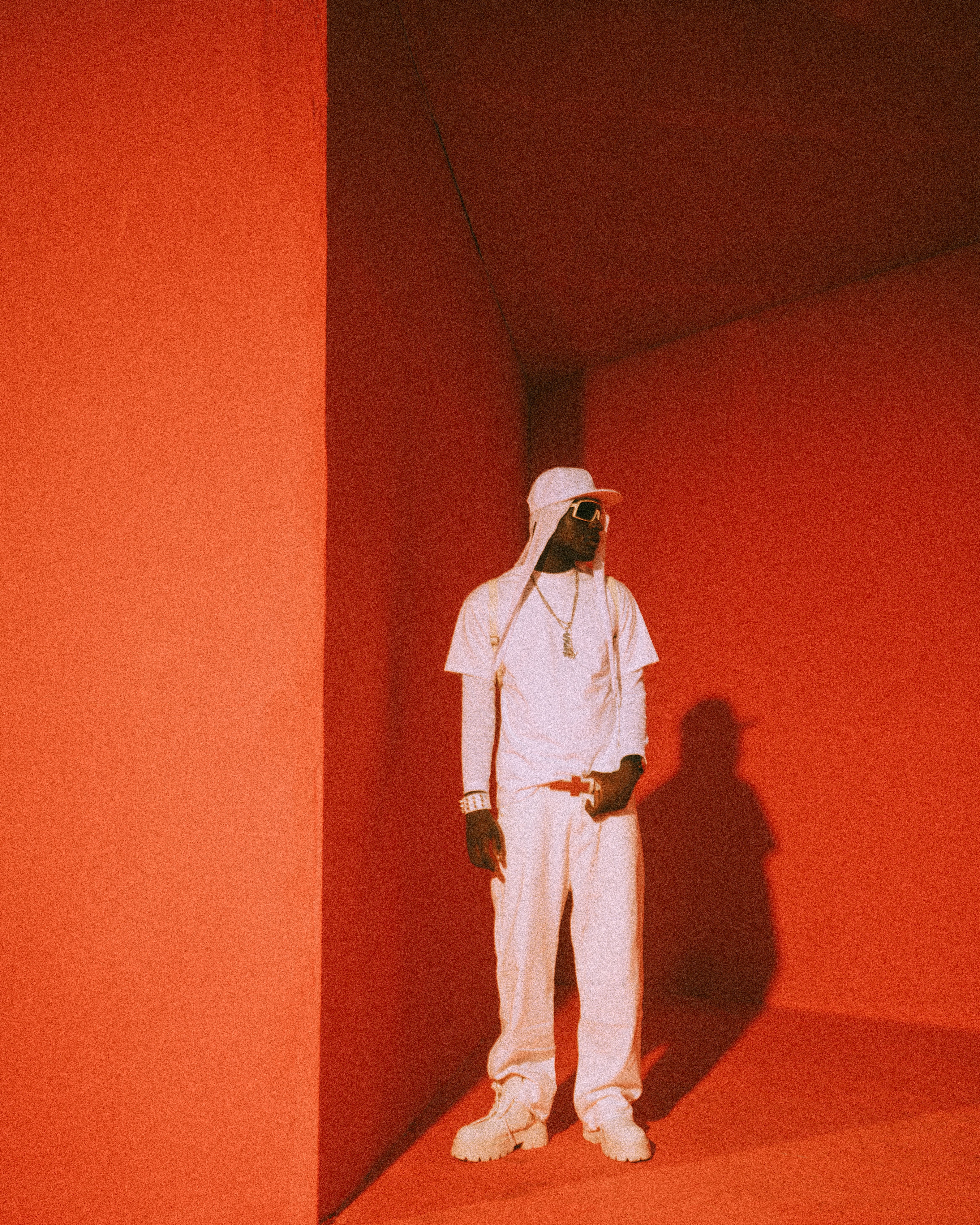 Stylish Man in White Outfit Against Red Background · Free Stock Photo