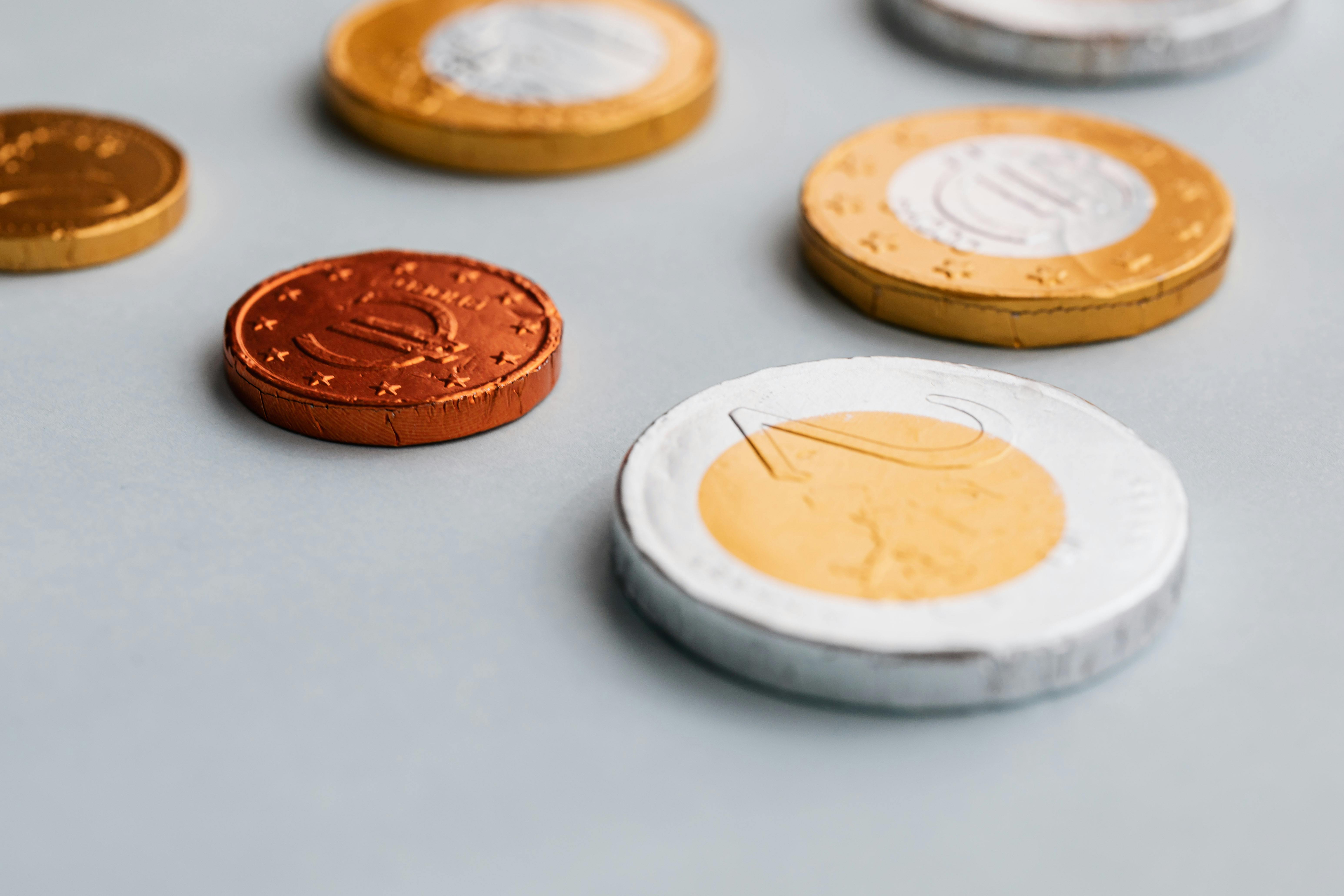 Chocolate coins on white surface by Karolina Grabowska