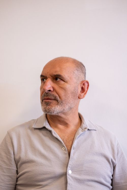 Free Middle-aged man looking contemplatively sideways in a casual environment, indoors. Stock Photo