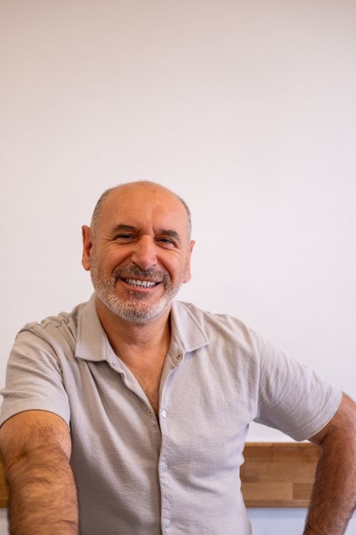 Free Middle-aged man smiling warmly in a casual setting, exuding positivity. Stock Photo