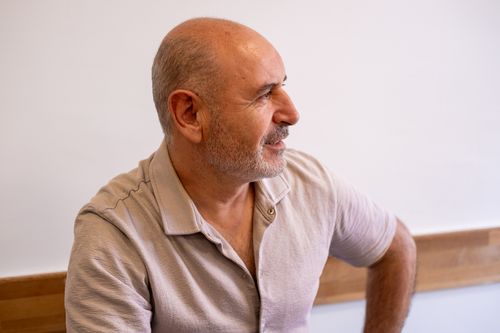 Free Side profile portrait of a mature man with a beard sitting indoors, captured in warm lighting in İzmir, Türkiye. Stock Photo