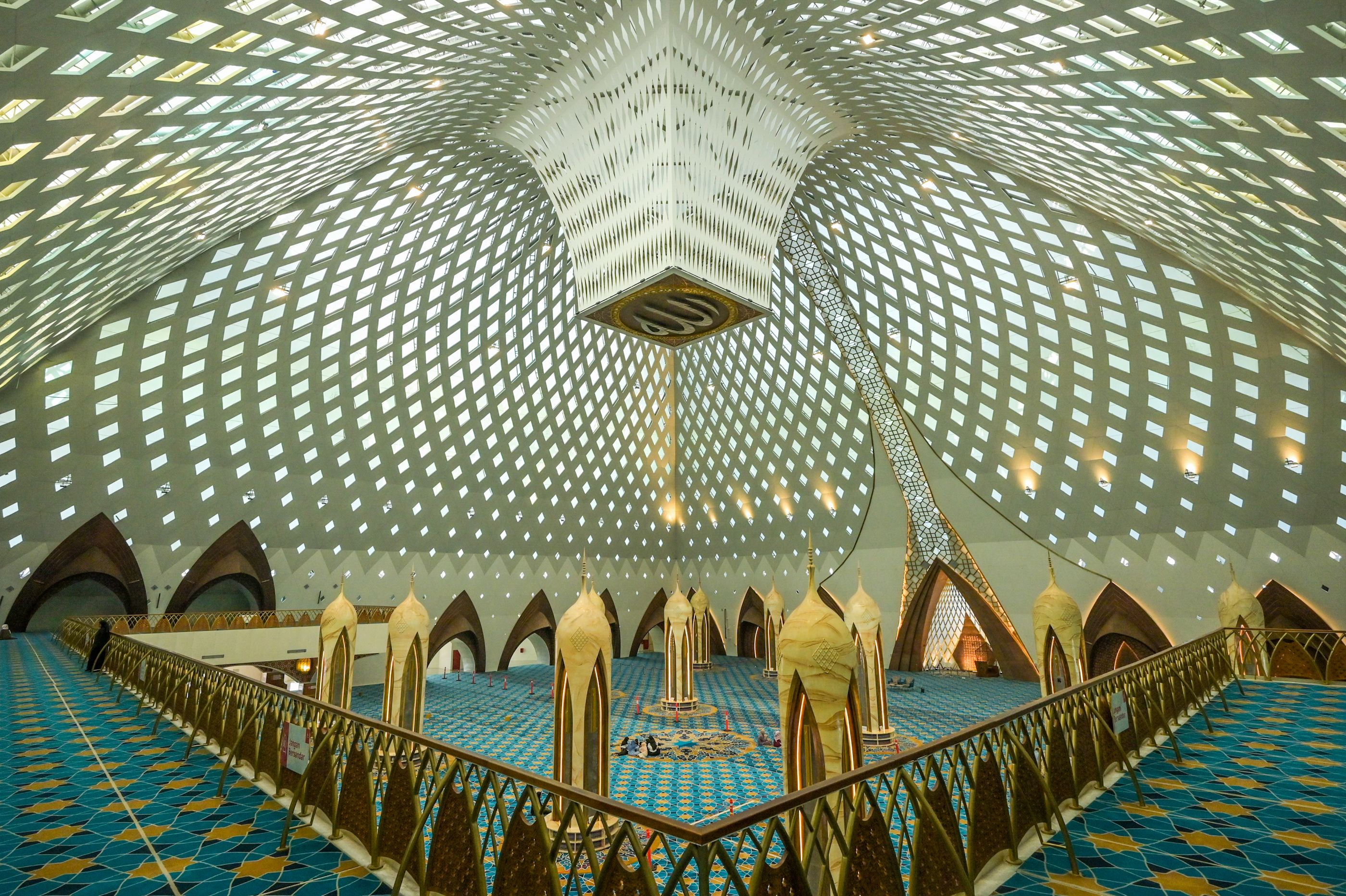 Elegant interior of a modern mosque featuring intricate geometric patterns and Islamic architecture.