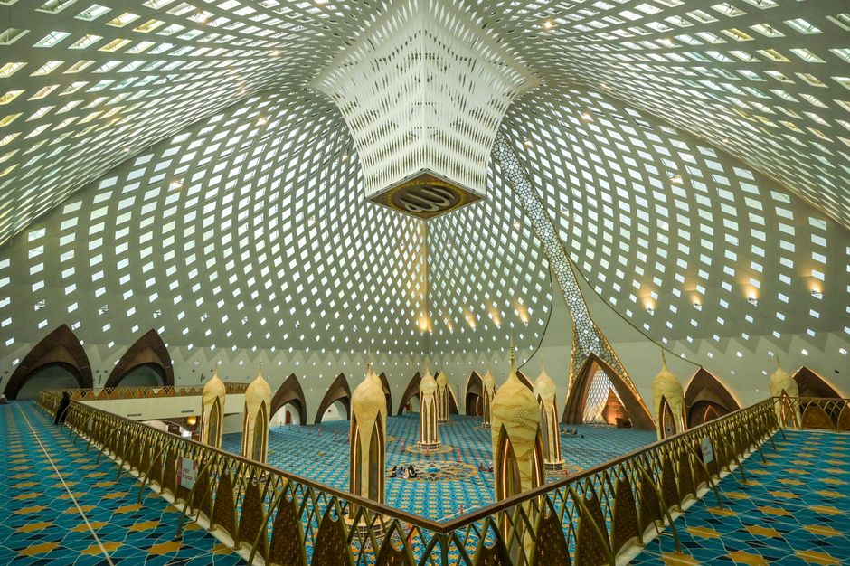 Elegant interior of a modern mosque featuring intricate geometric patterns and Islamic architecture.