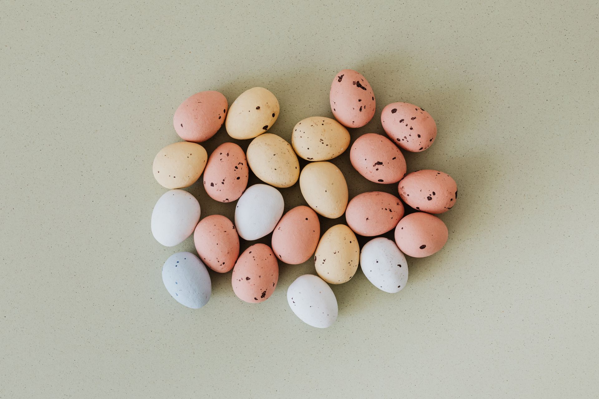A collection of speckled pastel Easter eggs laid out on a smooth surface, ideal for holiday themes.