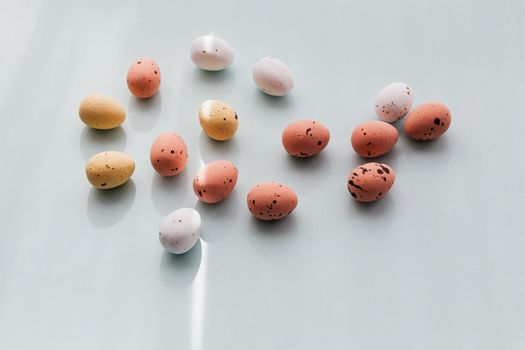 Pastel-colored Easter eggs with dotted patterns arranged on a light background, creating a minimalistic festive scene.