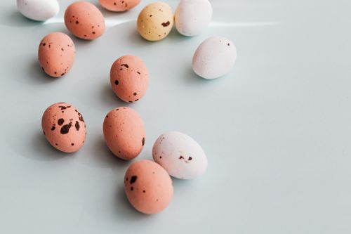 Free A collection of speckled Easter eggs on a pastel surface, perfect for seasonal themes. Stock Photo